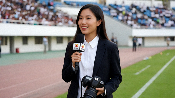 体育新闻现场，记者在赛场边进行赛事报道与采访拍摄